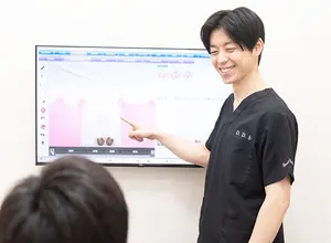 モニターを使って治療の説明をする歯科医師