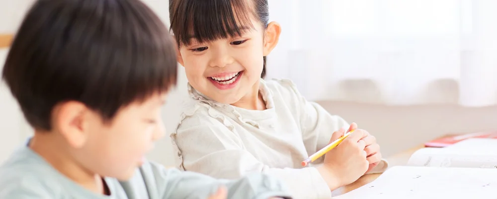 学びの時間に白い歯をのぞかせる子どもの様子 シティデンタルクリニック そよらリーフシティ市川